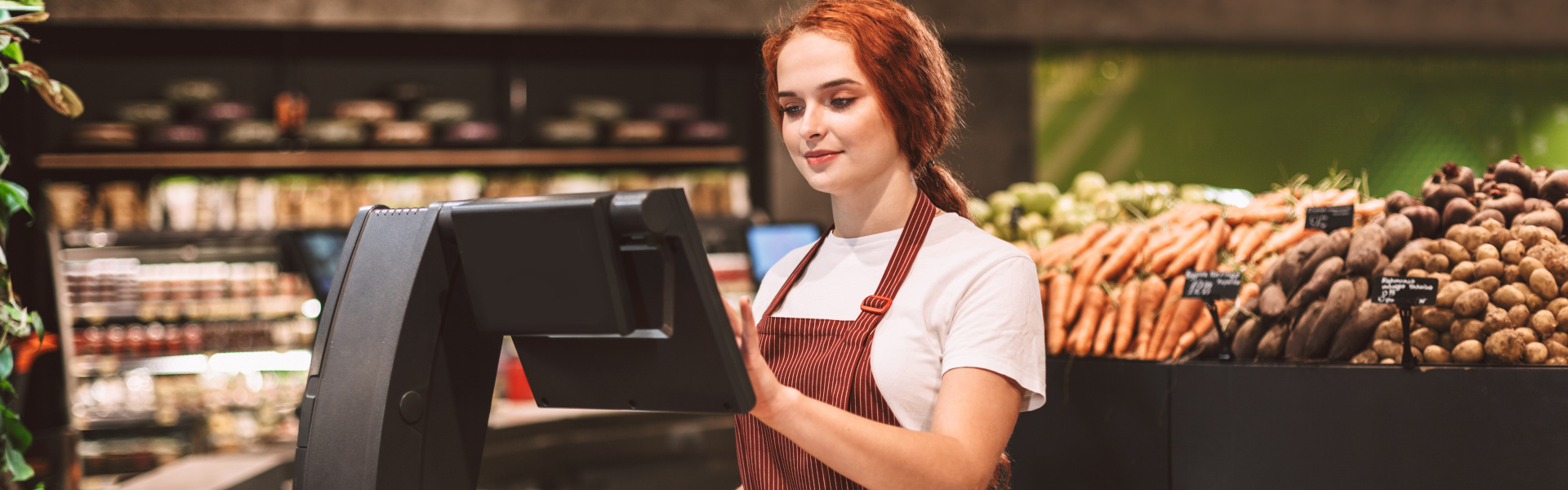 Mitarbeiterin wiegt Bananen an der Obst- und Gemüsetheke.